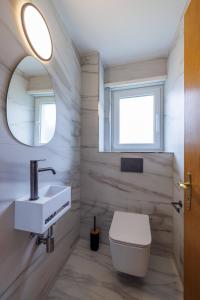 a bathroom with a toilet and a sink and a mirror at Luxe Davos Residence with Views Private Balcony in Davos