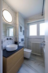 Un baño con lavabo, inodoro y espejo. en Luxe Davos Residence with Views Private Balcony, en Davos