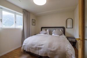 a bedroom with a bed with pillows and a window at Luxe Davos Residence with Views Private Balcony in Davos