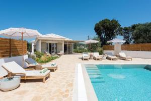 カシオピにあるVilla Bettinaの家の隣にある椅子とパラソルのあるプール