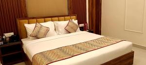 une chambre avec un grand lit avec des oreillers dans l'établissement Chocolate Inn, Patna, à Patna