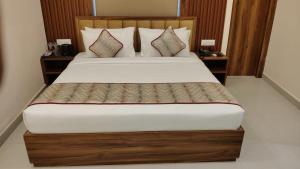 une chambre avec un grand lit avec deux tables de nuit dans l'établissement Chocolate Inn, Patna, à Patna