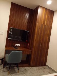 un bureau avec une télévision et une chaise dans une pièce dans l'établissement Chocolate Inn, Patna, à Patna 3 autres photos