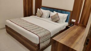 a bedroom with a large bed with a wooden headboard at Chocolate Inn, Patna in Patna