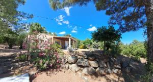 una casa con un muro in pietra e fiori di Villa avec piscine hors sol à 10mn de la plage a Lecci