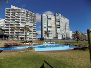 een groot appartementencomplex met een zwembad en twee gebouwen bij Coastal Hospitality - Beach Club 205 in Mosselbaai