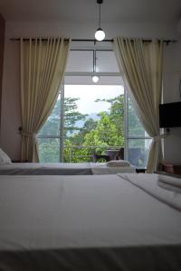 キャンディにあるHanthan Hotelのベッドが2つと大きな窓がある寝室
