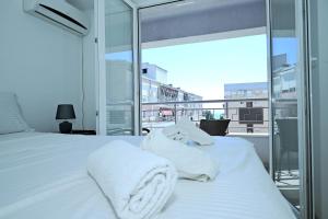 a bedroom with a white bed and a balcony at Lihnidos Home, Central Apartment, AC, Lake Access, Beach in Ohrid