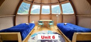 a room with two beds and a table in it at Fuji Dome Glamping in Fujikawaguchiko