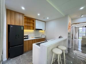 cocina con nevera negra y 2 taburetes en Caca villa 3 bedrooms, en Phu Quoc 21 fotos más
