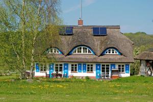 una casa con techo con panel solar. en Ferienwohnungen unterm Reetdach, en Ostseebad Sellin