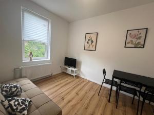 un soggiorno con un divano, un tavolo e una televisione di Modern & Comfortable Apartments in Central Altenburg ad Altenburg