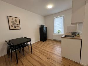 una cucina e una sala da pranzo con tavolo e frigorifero di Modern & Comfortable Apartments in Central Altenburg ad Altenburg
