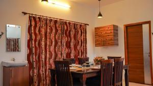 a dining room with a table and a sink at Willostays Cluster Clouds in Ooty