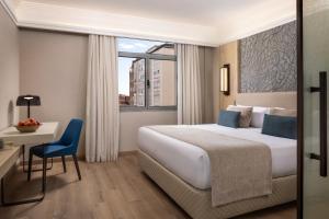 una stanza d'albergo con un letto, una scrivania e una finestra di VP SOGNIO Metropolitano a Madrid Altre 36 foto