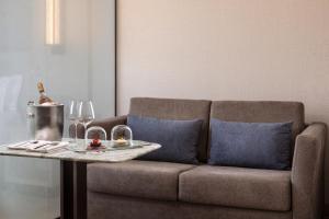 a living room with a couch and a table with wine glasses at VP SOGNIO Metropolitano in Madrid +29 photos