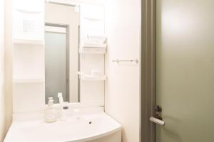 a white bathroom with a sink and a mirror at Rafore Building 26, Room 305 in Kumamoto