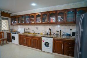 a kitchen with wooden cabinets and a washing machine at Garden apartment in Ksar es Sghir