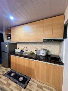 a kitchen with wooden cabinets and a black refrigerator at House in Davao for rent in Davao City