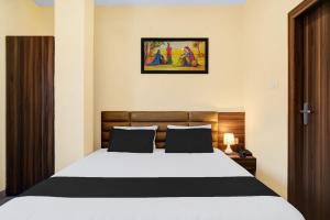 a bedroom with a large white bed in a room at Hotel O Barkura Bus Terminal Formerly Navanil in Nalbāri +11 photos