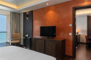 Una habitación de hotel con una cama y un televisor de pantalla plana. en Radisson Blu Hotel, Conakry, en Conakry