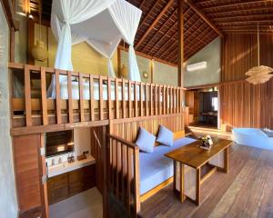 - un salon avec une mezzanine et une table dans l'établissement The Pulu Villas by GenuineHost, à Ubud