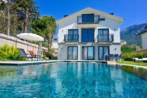 a villa with a swimming pool and a house at Aura luxury-Modern Stylish Central Holiday Villa For 6 Peeople in Fethiye
