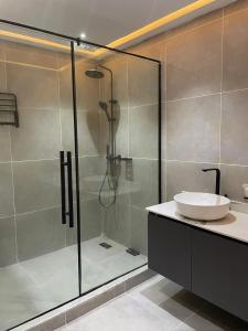 Un baño con ducha de cristal con lavabo. en Primes Apartments- Comfortable and well furnished 3 bedroom apartment perfect for relaxation, en Lagos