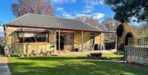 a small stone house with a fence in the yard at Our Cottage in Ross