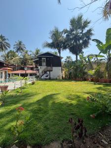 a house with a large yard with a green lawn at Samarth Krupa Beach Resort in Pālghar