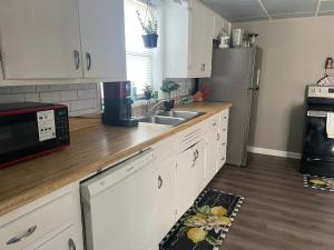 a kitchen with white cabinets and a stainless steel refrigerator at Beehive Cottage in Woodward