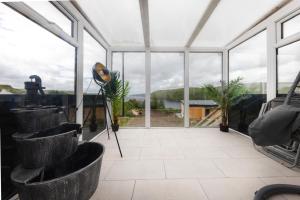 a greenhouse with large windows and a view of the water at Luxury Seaview Cottage by Fairy Pools 3 in Carbost