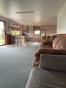 a living room with a couch and a kitchen at Our Cottage in Ross