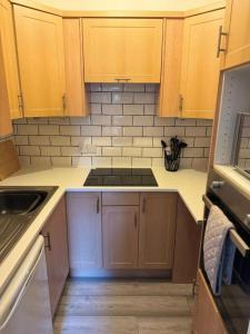 Una cocina con gabinetes de madera y un horno de estufa. en Stephen's Brae Apartment, Inverness City Centre, en Inverness