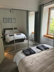 Un dormitorio con dos camas y un gran espejo. en Stephen's Brae Apartment, Inverness City Centre, en Inverness