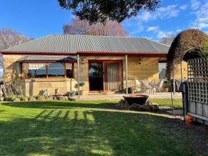a house with a fence in front of a yard at Our Cottage in Ross +10 photos