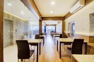a row of tables and chairs in a restaurant at Townhouse OAK Seventy Seven in Dum Dum