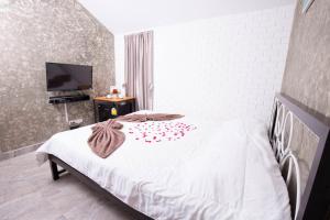 ein Schlafzimmer mit einem weißen Bett mit roten Blumen darauf in der Unterkunft V Village Hotel Saraburi in Ban Muak Lek + 36 Fotos