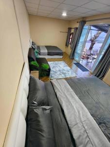 un salon avec deux lits et un canapé dans l'établissement Bansuanariya บ้านสวนอริยะ, à Ban Na Yang