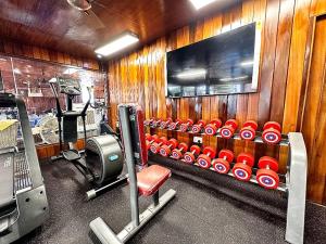 a room with a gym with a chair and a tv at Golden Crystal Hotel in Accra