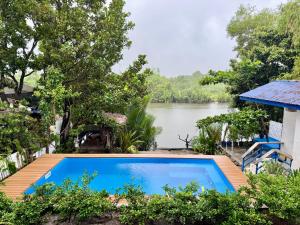 a swimming pool with a view of a river at Azul Zambales Beachfront House & River Cottages EXCLUSIVE in Cabangan