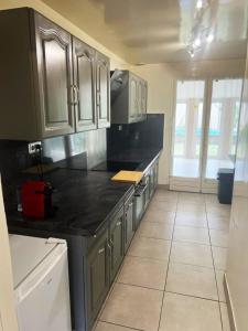 オーベルヴィリエにあるSpacious house ideally locatedの白いキャビネットと黒いカウンタートップを備えたキッチン