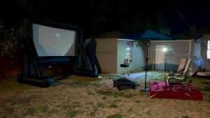 a tv and an umbrella in a yard at night at Beehive Cottage in Woodward