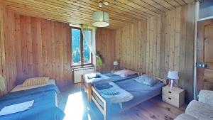 two beds in a room with wooden walls at CASA-Suite La Bohème pour 5 personnes in Molines-en-Queyras