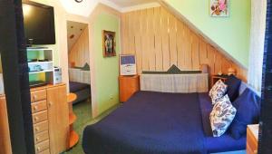 a bedroom with a blue bed and a staircase at Homestay Kuchařovice in Kuchařovice
