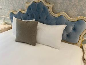 a bed with a blue and gold headboard and pillows at Lane 82 Hostel in Chiayi City +21 photos