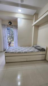 a bed in a room with a window at CASA HILLSIDE Dapoli 2BHK AC Apartment in Dapoli +9 photos