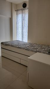 Ce lit se trouve dans un dortoir doté d'une fenêtre et de matelas. dans l'établissement CASA HILLSIDE Dapoli 2BHK Apartment, à Dapoli