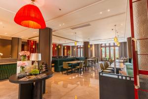 a restaurant with green chairs and tables and a red lamp at Horkeo Boutique Hotel in Xam Nua