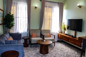 Una sala de estar con un sofá y un televisor. en Olkerian Lavish Apartments, en Arusha